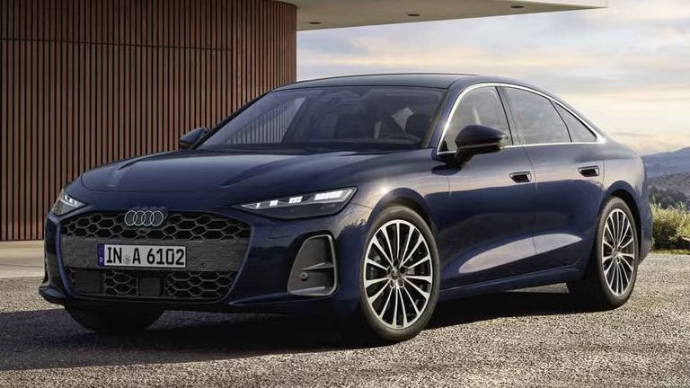 Die A6 Limousine steht im schrägen Frontprofil vor einem modernen Haus. 