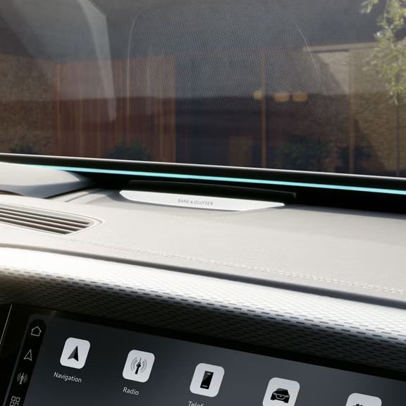 Das Armaturenbrett und Beifahrerdisplay aus der Perspektive des Beifahrers. Unter der Windschutzscheibe ist das Interaktionslicht in hellblau zu erkennen. 