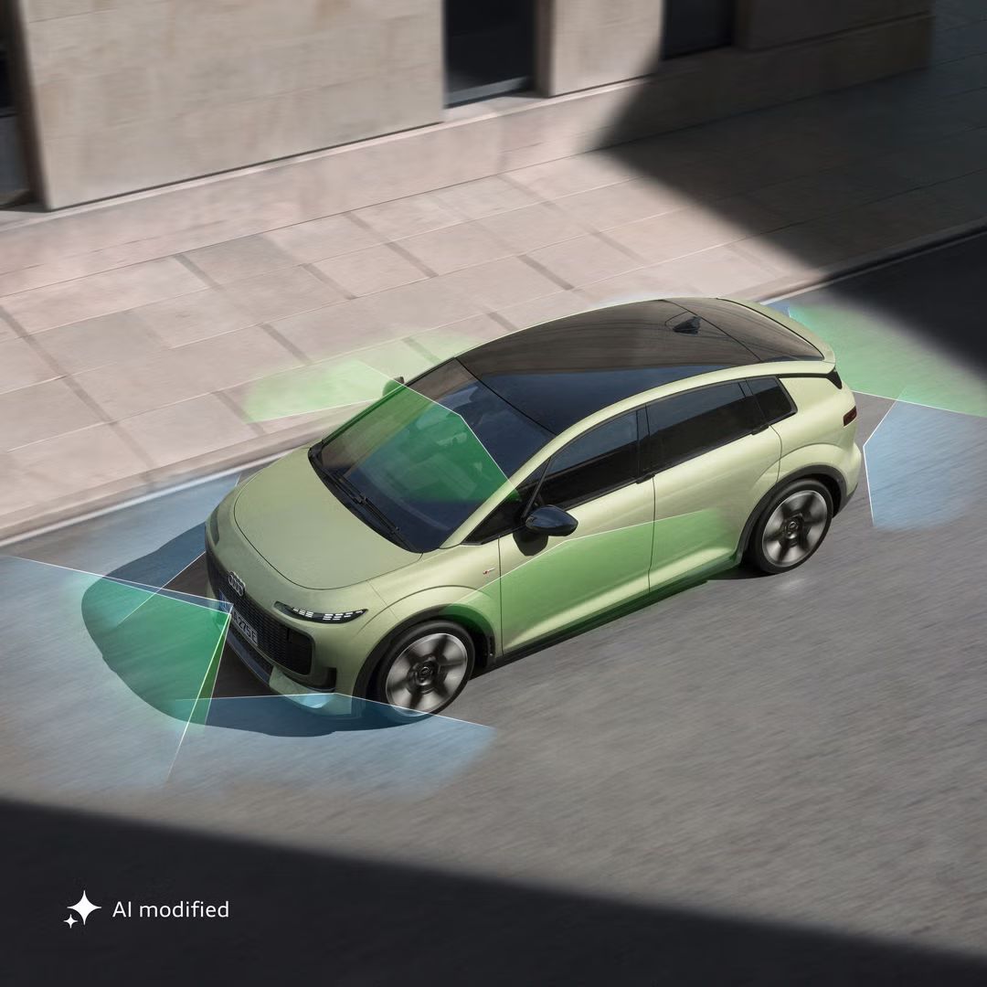 Der Audi A2 e-tron schräg von oben in einer Straßenschlucht. Die Sonne beleuchtet das Fahrzeug, während Teile der Umgebung im Schatten liegen. Vom Heck und der Front aus unterteilen grüne und blaue Vektoren die Flächen hinter und vor dem Fahrzeug.