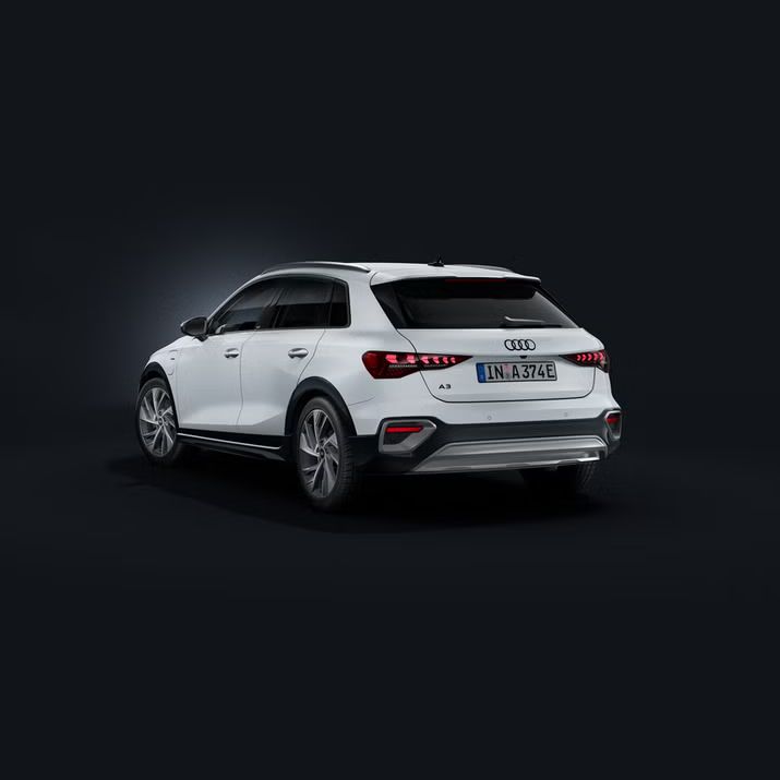 Der Audi A3 Sportback e-hybrid schräg von hinten auf dunklem Hintergrund.