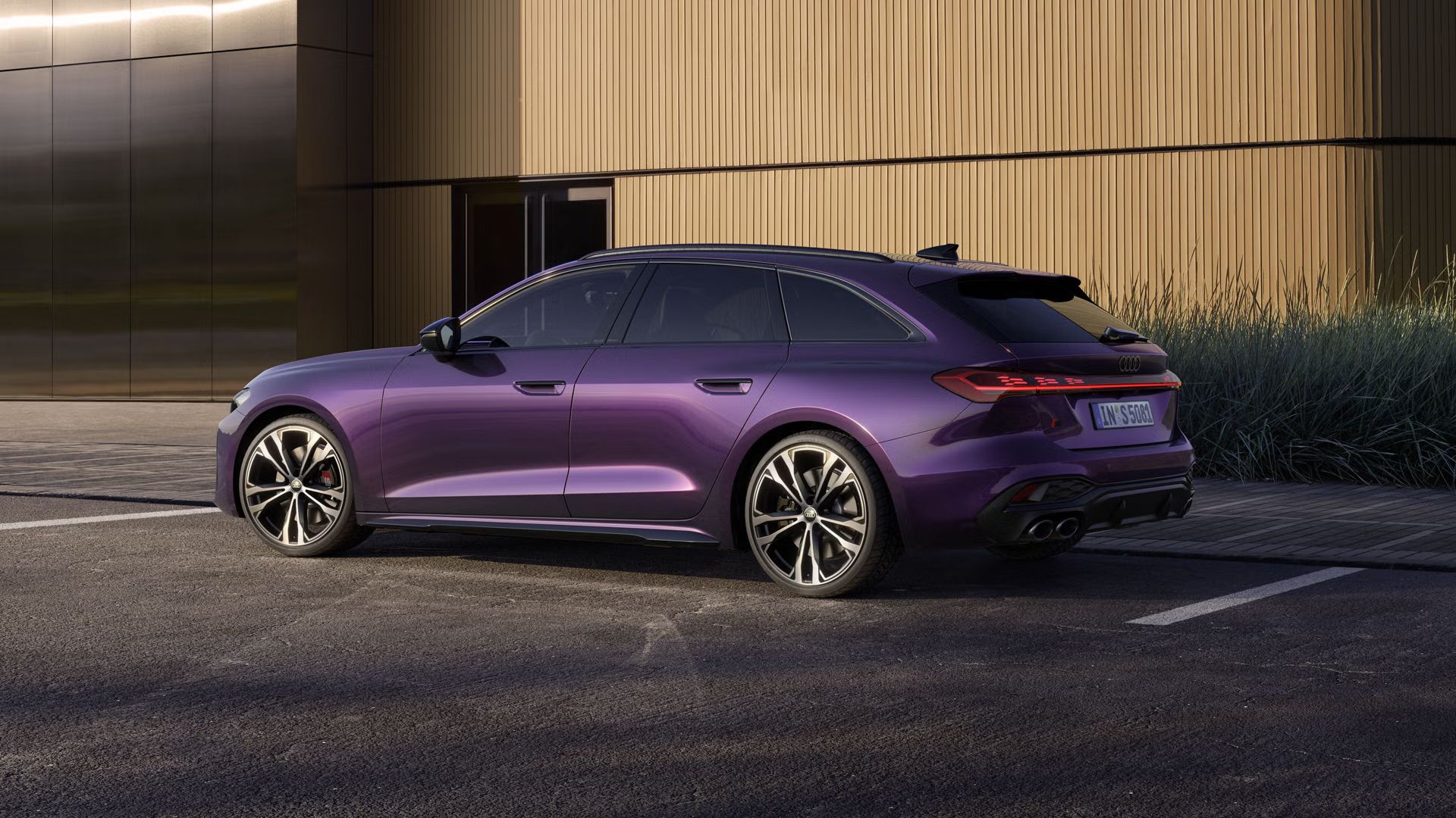 Der S5 Avant in Merlin Perleffekt steht auf einem Parkplatz vor einem Gebäude, seitlich fotografiert.