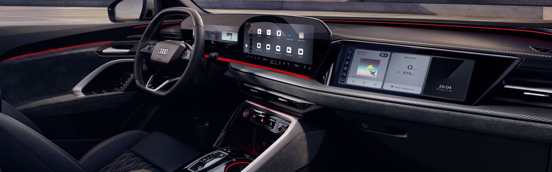 Blick durch das Beifahrerfenster in das Cockpit des SQ5 SUV. Zu sehen sind unter anderem das Panoramadisplay, das MMI Beifahrerdisplay, sowie die rote Ambiente Beleuchtung.
