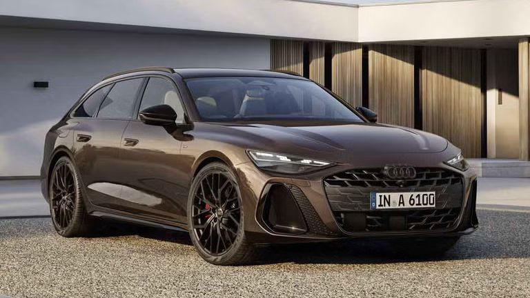 Der A6 Avant steht im schrägen Frontprofil auf einer Kiesfläche vor einem modernen Haus. Die Frontscheinwerfer des Fahrzeugs zeigen eine Lichtsignatur.