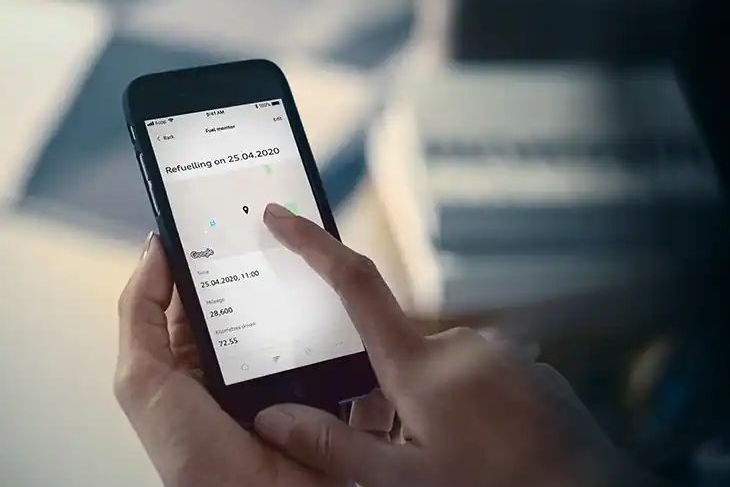 Eine Frau bedient ihre Audi plug and play App am Handy.