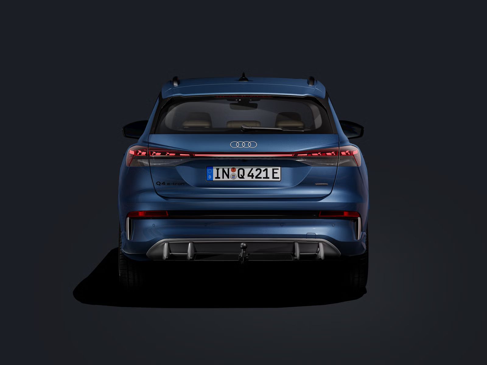 Heckansicht des Q4 SUV e-tron auf dunklem Hintergrund.