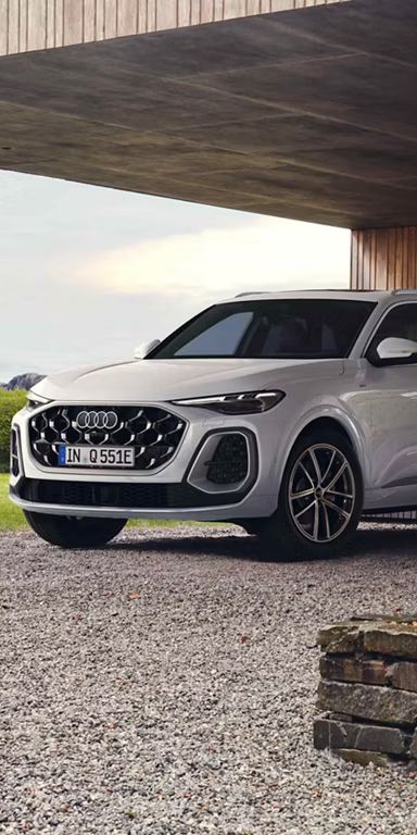 Audi Q5 SUV e-hybrid Seitenansicht vor einem Haus beim Laden 